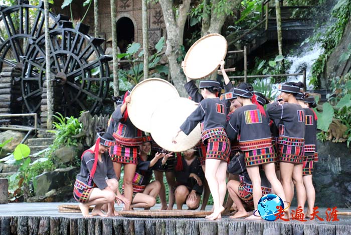 4 三亚姑娘在槟榔谷黎族寨子表演农家舂米歌舞.JPG