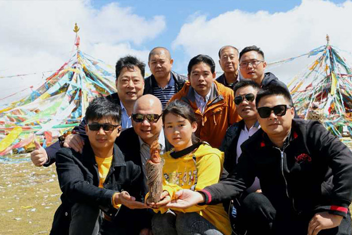 10在海拔3000多米的青藏高原，藏族姑娘卓瑪和參訪團一起托起胡楊木雕刻的關公像.jpg
