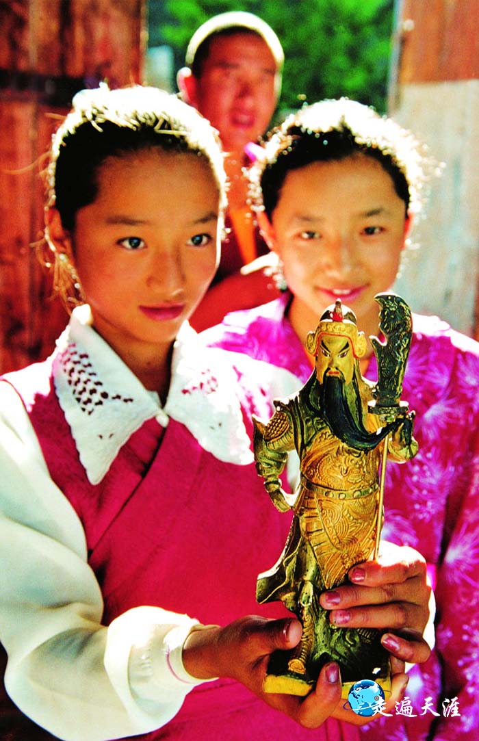 2 藏族小姑娘琼达在拉萨关帝庙托举着喇嘛制作的关公像.jpg