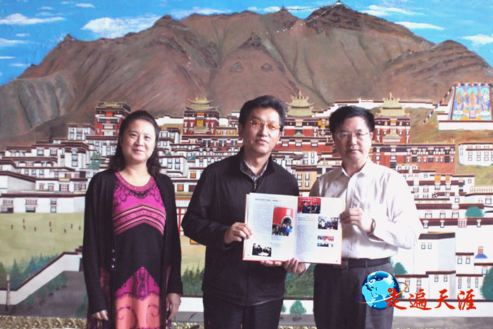 2 摄影家朱正明在西藏日喀则向西藏自治区政协副主席阿佩晋源赠送《世界关帝文化》画册，左为崔玉晶女士.JPG